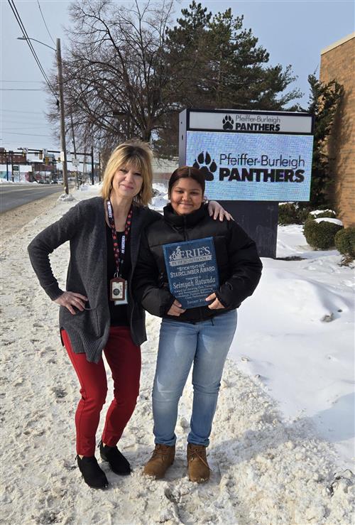 Seimyah Rotunda, Pfeiffer-Burleigh's Stairclimber recipient for the month of January, poses with her plaque and staff member.